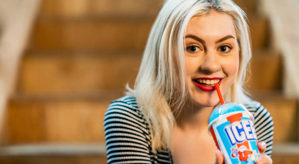 A woman drinking an ICEE