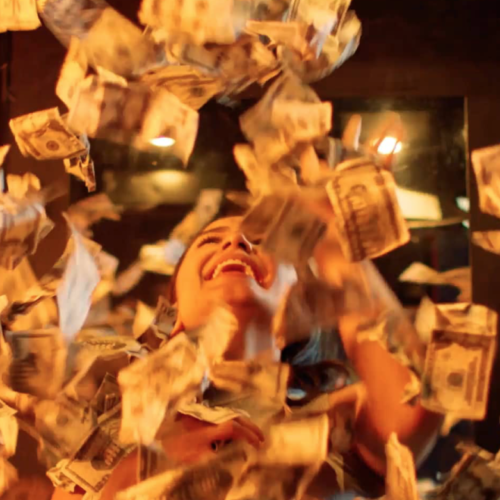 Woman in cube surrounded by flying cash