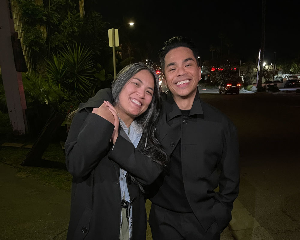 Joann Mercado Hicks and a colleague happily embrace under the night sky.