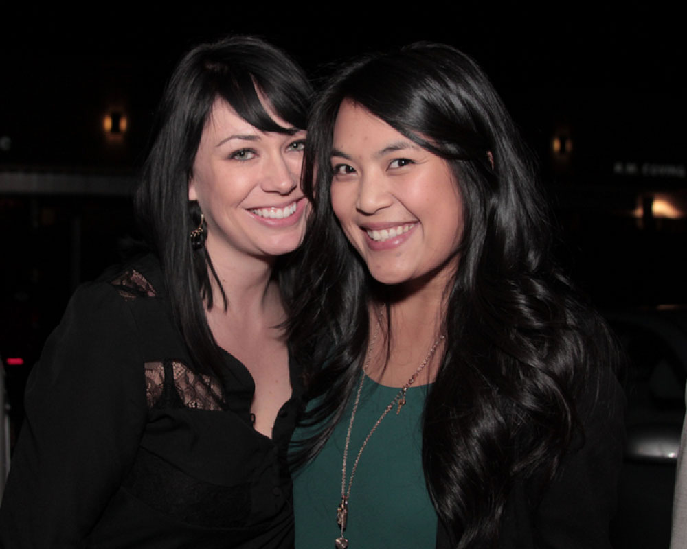Joann Mercado Hicks and Sara Bourbeau with big smiles during a nighttime outing, celebrating her recognition at Windsong Productions.